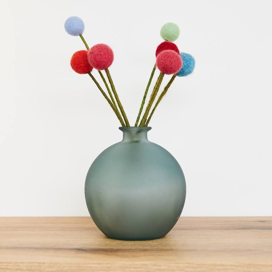 Dekorative Vase mit bunten Filzkugeln als Sinnbild für kreative Perspektivwechsel in der Supervision